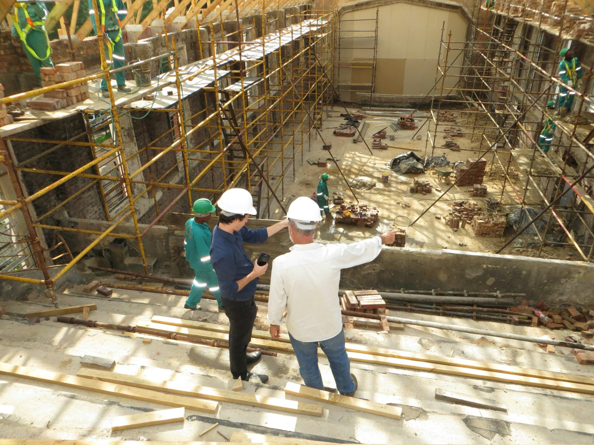 Two men in discussion as they oversee a construction project. Image credit: Mark Potterton, Unsplash.