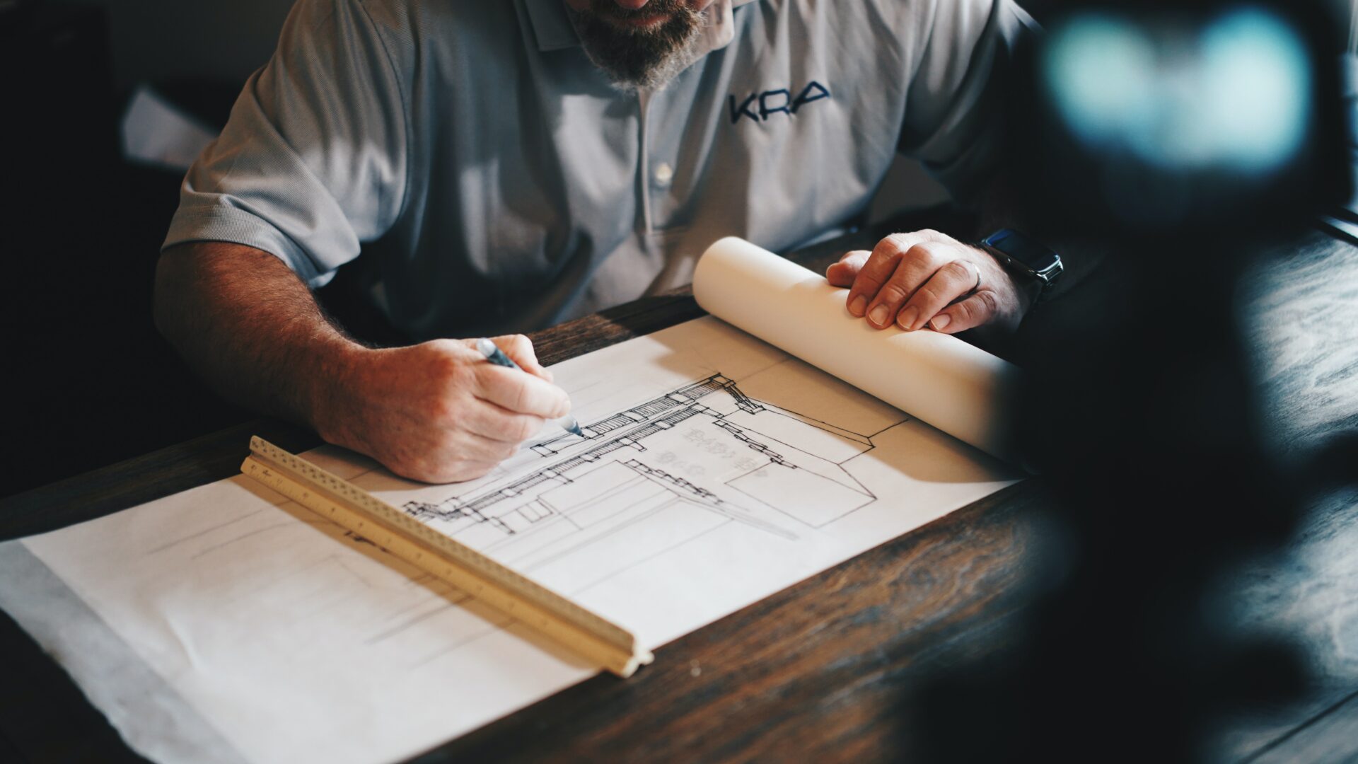 Photo of an architect working on a draft blueprint by Daniel McCullough on Unsplash